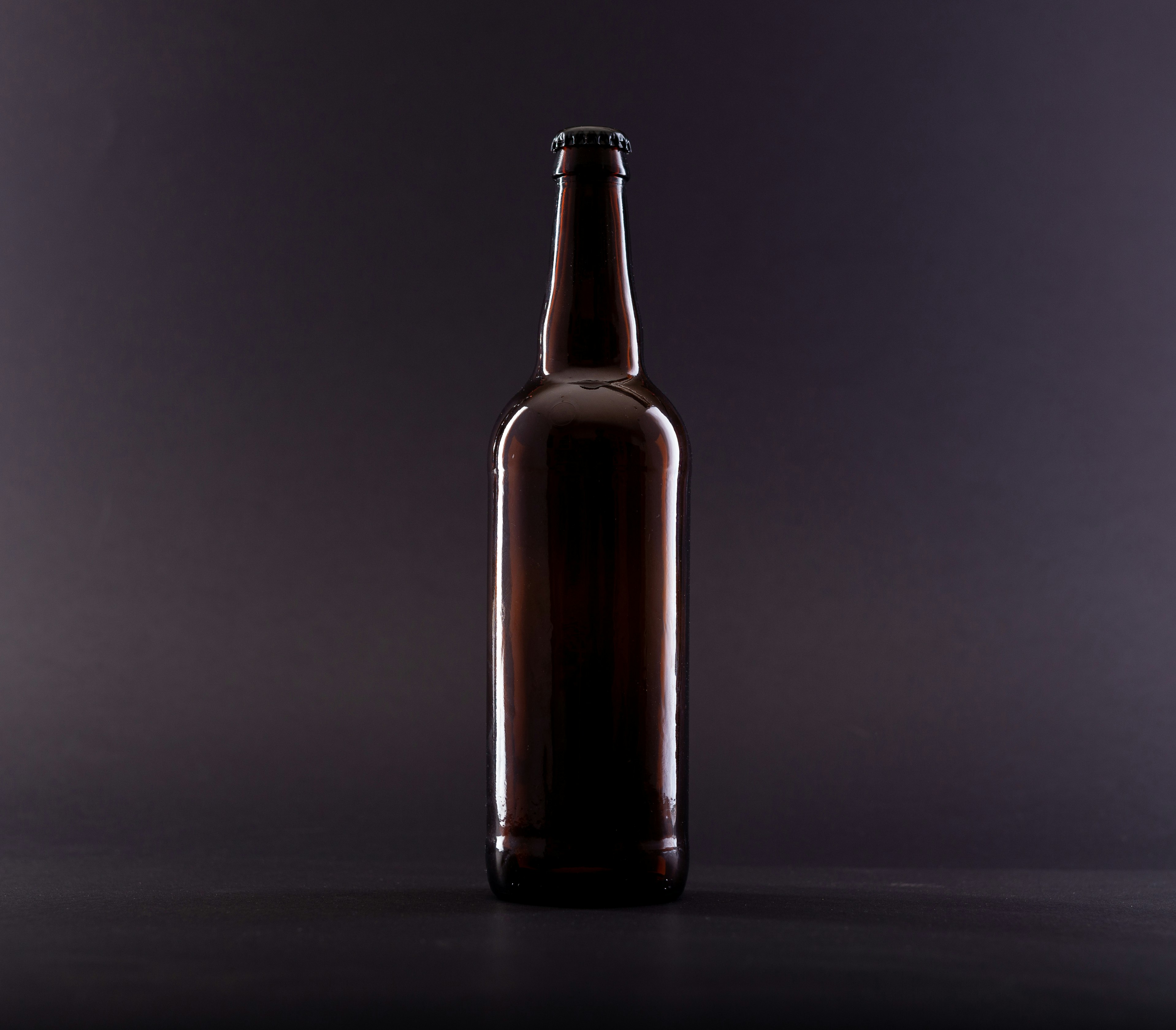 brown glass bottle on black surface